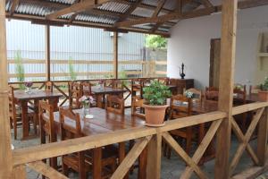 una sala da pranzo con tavoli e sedie in legno di Sofia House a Kobuleti