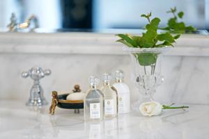 a group of bottles on a counter with a vase at Palais Ronsard Relais & Chateaux in Marrakech