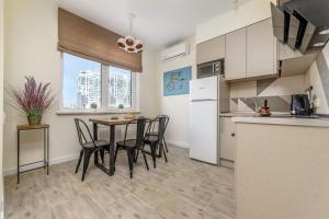 a kitchen and dining room with a table and chairs at Arcadia Sweet LOFT Style! in Odesa