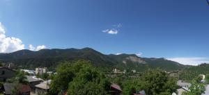 a plane flies over the mountains at Akaki's Guesthouse in Borjomi