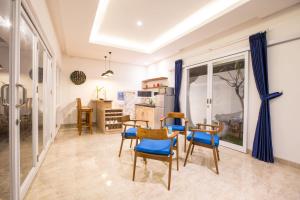 une salle à manger avec des chaises bleues et une table dans l'établissement Villa Ultima Umalas, à Canggu