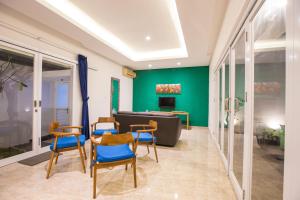 - un salon avec des murs verts et des chaises bleues dans l'établissement Villa Ultima Umalas, à Canggu