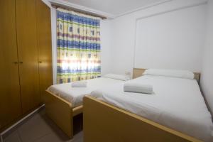 sypialnia z 2 łóżkami i oknem w obiekcie Patacona Resort Apartments Primera Linea w Walencji