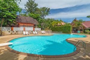 a swimming pool with chairs and a house at Lanta Manda Resort in Ko Lanta