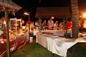 a group of people standing around tables with food at Mukdara Beach Villa & Spa Resort in Khao Lak