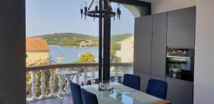 une salle à manger avec vue sur l'eau dans l'établissement Apartments Perina, à Tisno