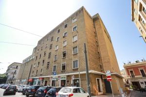 un grand bâtiment en briques dans une rue avec des voitures garées dans l'établissement Marconi 7- City Centre Apartment SIT, à Lecce