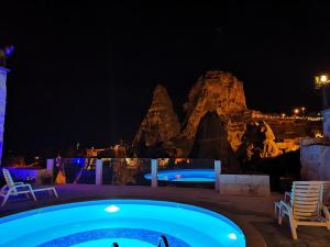 ウチヒサールにあるエルメス ケーブ ホテルのリゾートのプールの夜景を望めます。