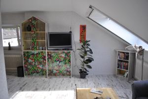 a living room with a tv and a book shelf at gemütliche Zimmer im Einfamilienhaus in Cologne