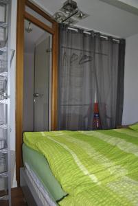 Un dormitorio con una cama verde y una ventana. en gemütliche Zimmer im Einfamilienhaus, en Colonia