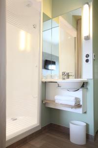 a bathroom with a sink and a mirror at Hotel Ibis Budget Abbeville in Abbeville