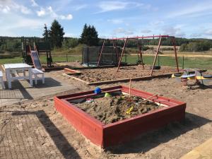 a sandbox and a swing set in a sandbox at Broby Bed & Breakfast entréplan in Nyköping
