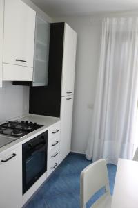 una cucina con mobili bianchi e un forno a piano cottura di Boa Vista Favignana - Home&Beach a Favignana