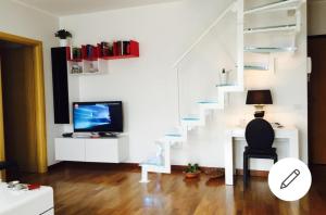 a living room with a staircase and a television at Aurelia House in Rome