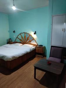 a bedroom with a large bed and a table at Hotel Madhuban Shimla in Shimla