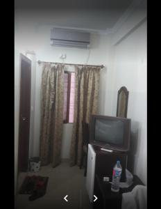 ein Wohnzimmer mit einem TV und einem TV-Stand in der Unterkunft A.K Hotel in Lahore