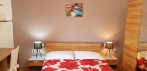 - une chambre avec un lit et deux lampes sur deux tables dans l'établissement Apartments Perina, à Tisno