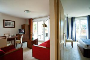 a hotel room with a bed and a desk and a bedroom at Goélia Mandelieu Riviera Resort in Mandelieu-la-Napoule