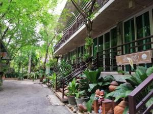 ルーイにあるLoei Huen Hao Hug Home&Resortの植物がたくさん立ち並ぶ建物