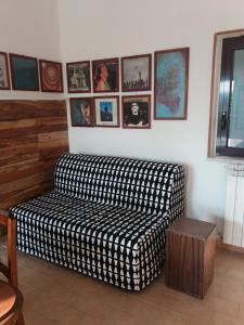 a couch in a living room with pictures on the wall at CAMPO BASE B&B in SantʼAngelo in Pontano +18 photos