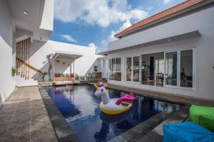 une piscine avec un flot de maïs dans une maison dans l'établissement Villa Ultima Umalas, à Canggu