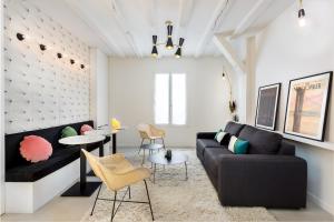 een woonkamer met een zwarte bank en tafels en stoelen bij Montorgueil Suite in Parijs