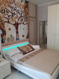 a bedroom with a bed with a painting on the wall at Tree House in Cassano dʼAdda