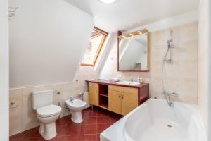 a bathroom with a tub and a toilet and a sink at 3 storey Apartment w/Terrace in Riga