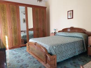 1 dormitorio con 1 cama y armarios de madera en Casa Vacanze Fontanelle en Badolato
