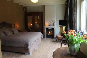 a bedroom with a bed and a fireplace at Bosgeluk in Helmond