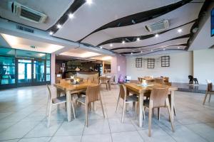 a dining room with wooden tables and chairs at Hotel Tigra in Priekuļi