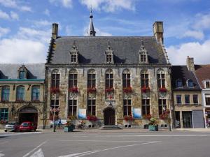 an old building with flowers in front of it at F4 duplex neuf et moderne, proche de Dunkerque in Hondschoote