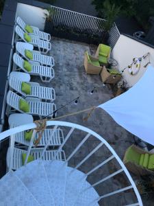 eine Gruppe Stühle und ein Sonnenschirm auf einer Terrasse in der Unterkunft Hotel Imperium in Chełmża