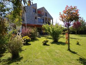 a garden in front of a house with trees at Hosteria La Moraleja in Solares