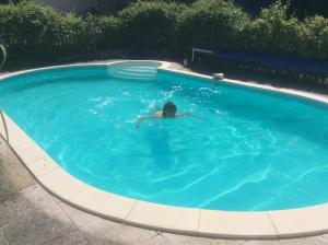 a person swimming in a swimming pool at La Petite Maison in Crézières