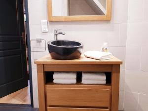 a bathroom with a black sink on a wooden table at La Parenthèse in Amboise