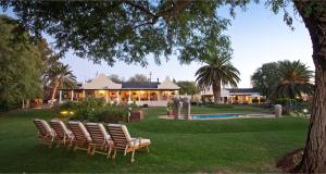 a group of chairs sitting in front of a house at Thylitshia Villa Country Guest House in Oudtshoorn