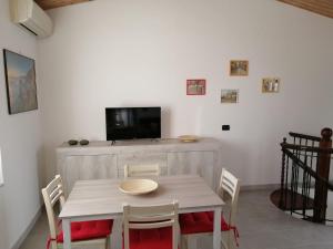 a dining room with a table with chairs and a tv at Sentieri sul Mare in Moneglia
