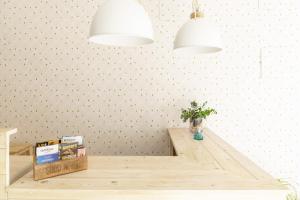 una mesa de comedor con dos luces y un jarrón de flores en Hostal Beni en Benicàssim