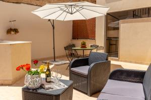 patio ze stołem, krzesłami i parasolem w obiekcie Residenza del Duca - Casteldaccia 2 camere w mieście Casteldaccia