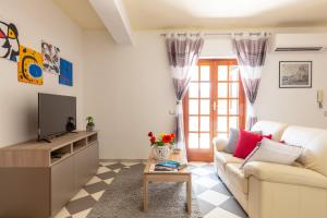 salon z kanapą i telewizorem w obiekcie Residenza del Duca - Casteldaccia 2 camere w mieście Casteldaccia