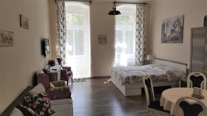マリアーンスケー・ラーズニェにあるApartment Marienbad Hlavni 131/50のベッドルーム1室(ベッド1台、ソファ1台、窓2つ付)