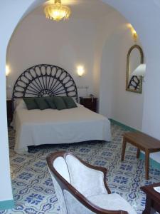 a bedroom with a bed and a chair and a table at Hotel Parsifal - Antico Convento del 1288 in Ravello