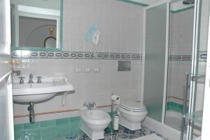 a bathroom with a sink and a toilet and a mirror at Hotel Parsifal - Antico Convento del 1288 in Ravello
