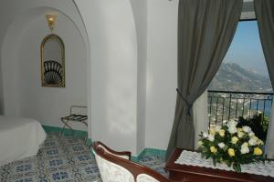 a room with a balcony with a table with flowers on it at Hotel Parsifal - Antico Convento del 1288 in Ravello