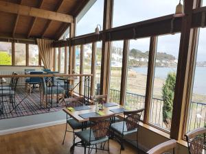 un restaurante con mesas y sillas y vistas al océano en Ferry House Inn en Milford Haven