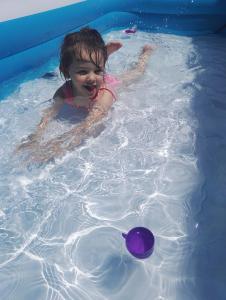 een klein meisje zwemmend in een zwembad met een bal bij Hânetül Mabeyn in Rize