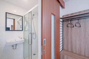 ein Bad mit einer Dusche, einem Waschbecken und einer Tür in der Unterkunft Canggu Residence in Canggu + 30 Fotos