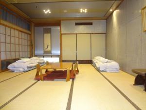 a room with a table and two beds at Asano Hotel in Kitakyushu