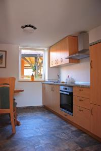 a kitchen with wooden cabinets and a table and a window at Noah Apartment in Radovljica